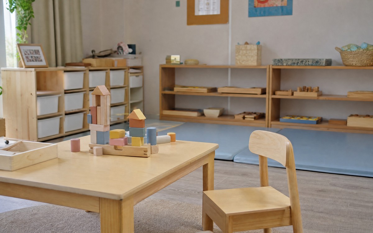 Anaokulu sınıfının sakin köşesi: alçak masa, ahşap bloklar ve oyun matı