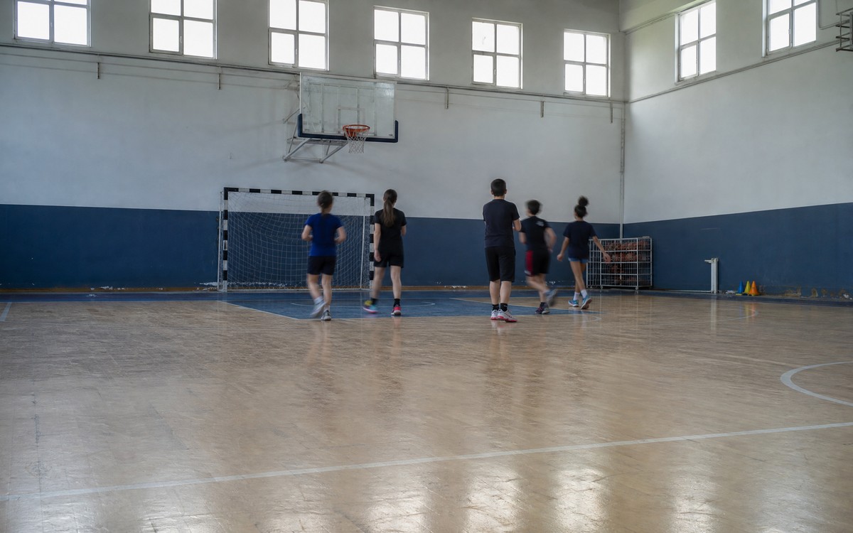 Antrenman öncesi spor salonu: ısınan bir grup ve kenarda ekipman
